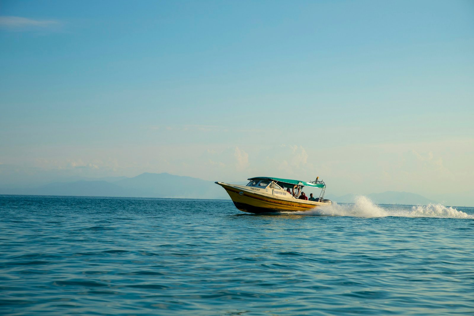 Le sillage d'un bateau à moteur au large, en fin d'après-midi