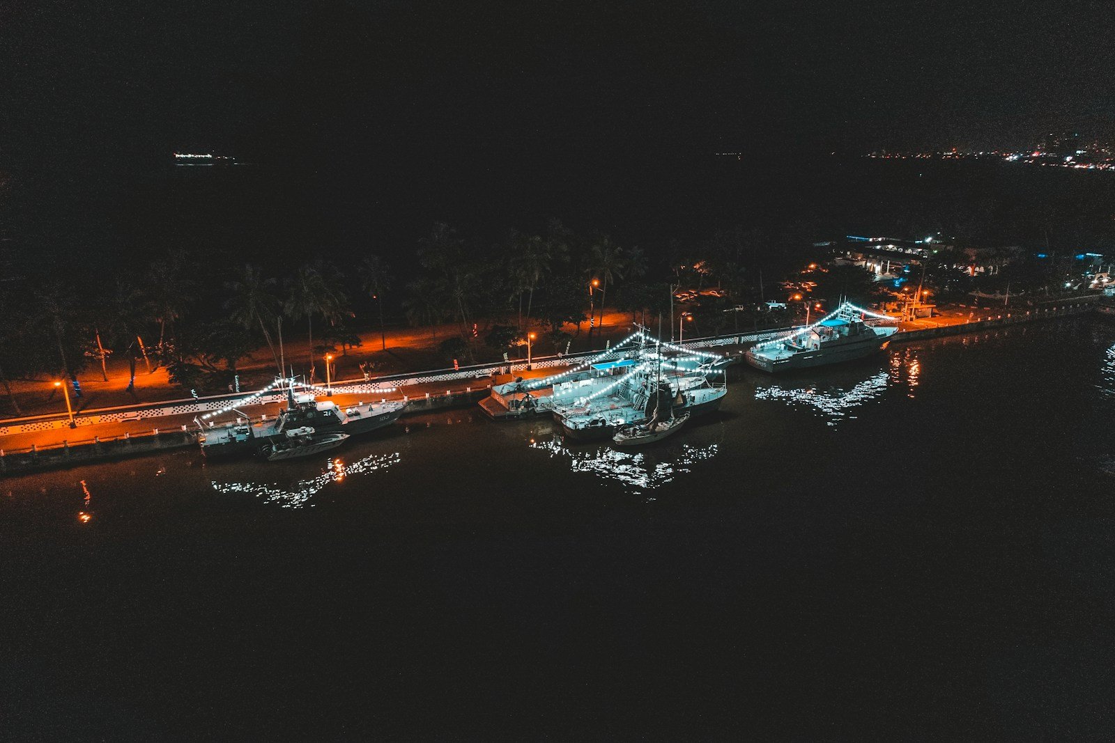 Pontons d'un port de plaisance la nuit, lumières reflétées sur l'eau