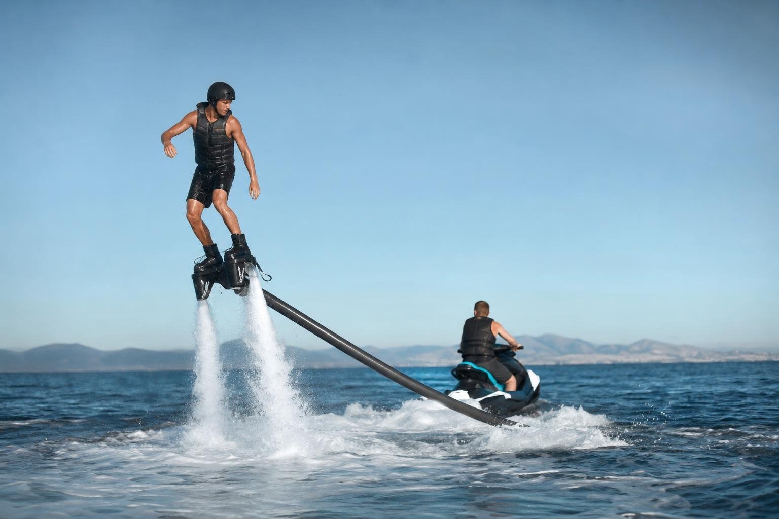 Un engin nautique hydropropulsé en vol au-dessus de la mer, relié par un tuyau au jet-ski qui l'alimente