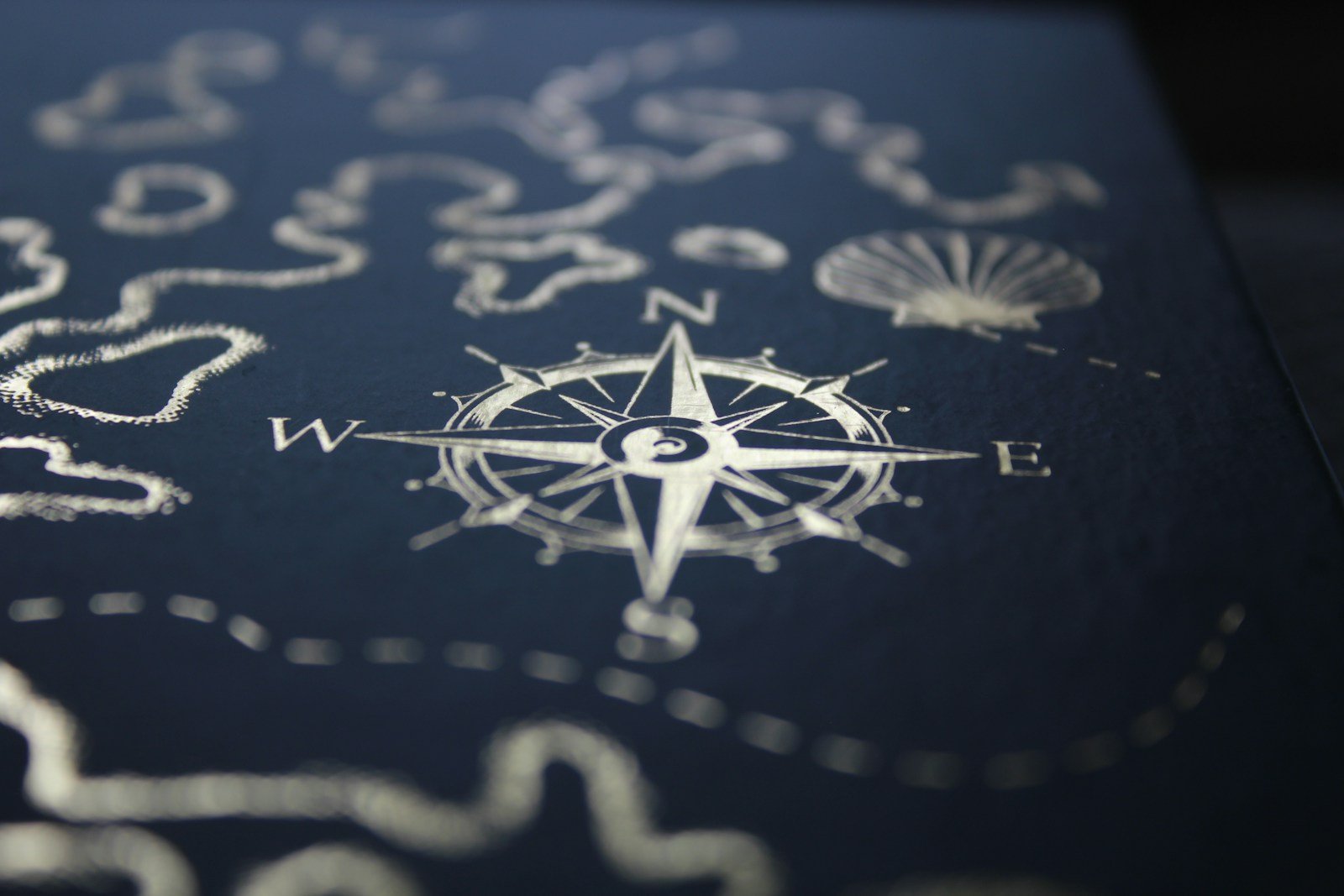 Une carte marine et un compas posés sur une table de navigation