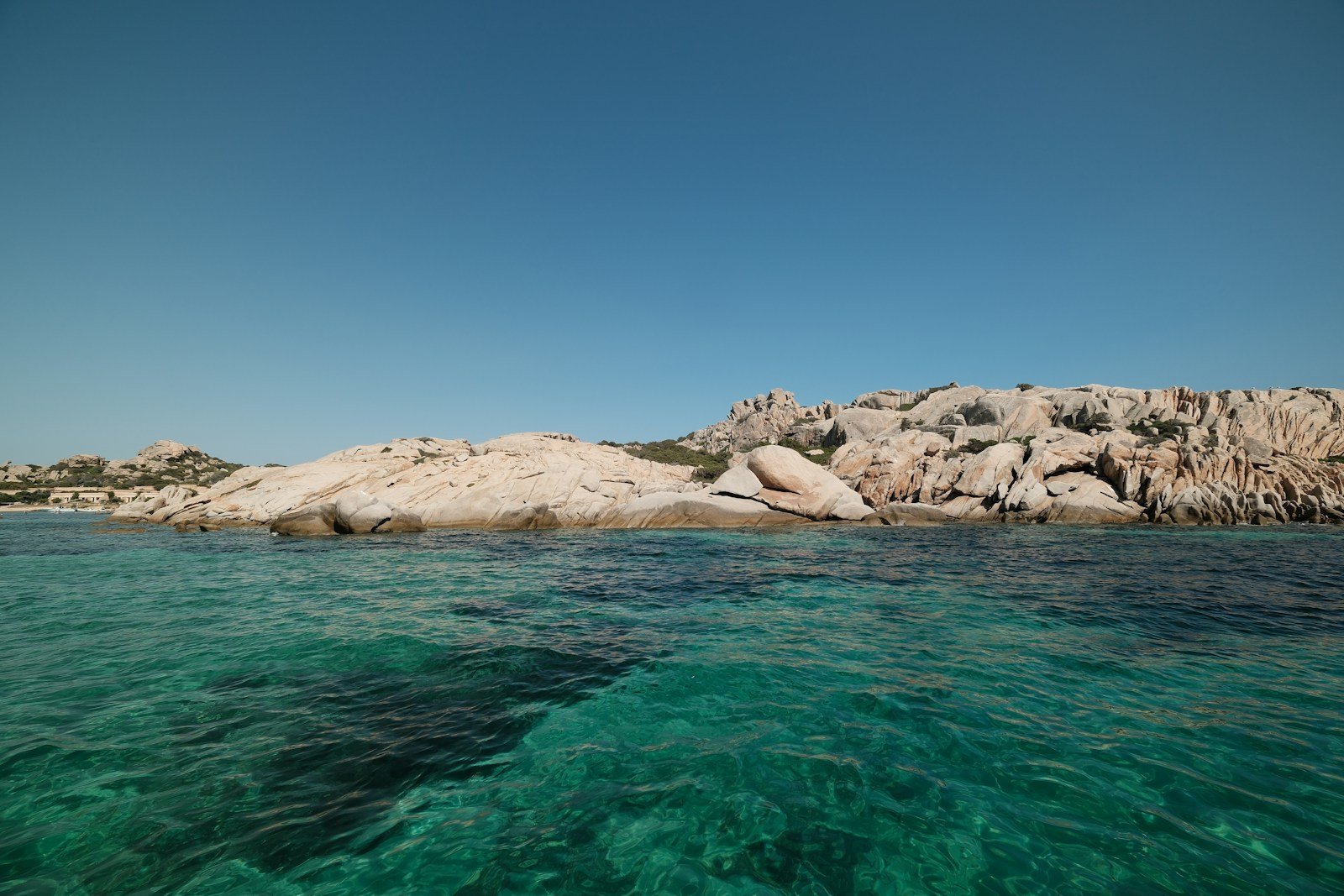 Baie corse aux eaux turquoise bordée de rochers de granit et de pins