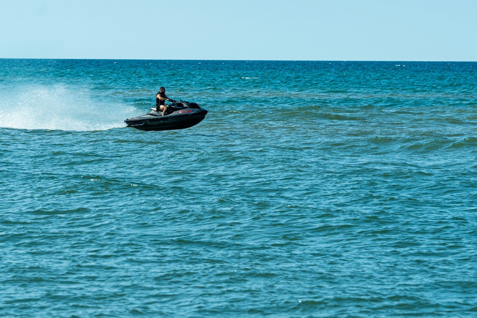 Pilote de scooter des mers de face, gerbe d'eau sur les flancs