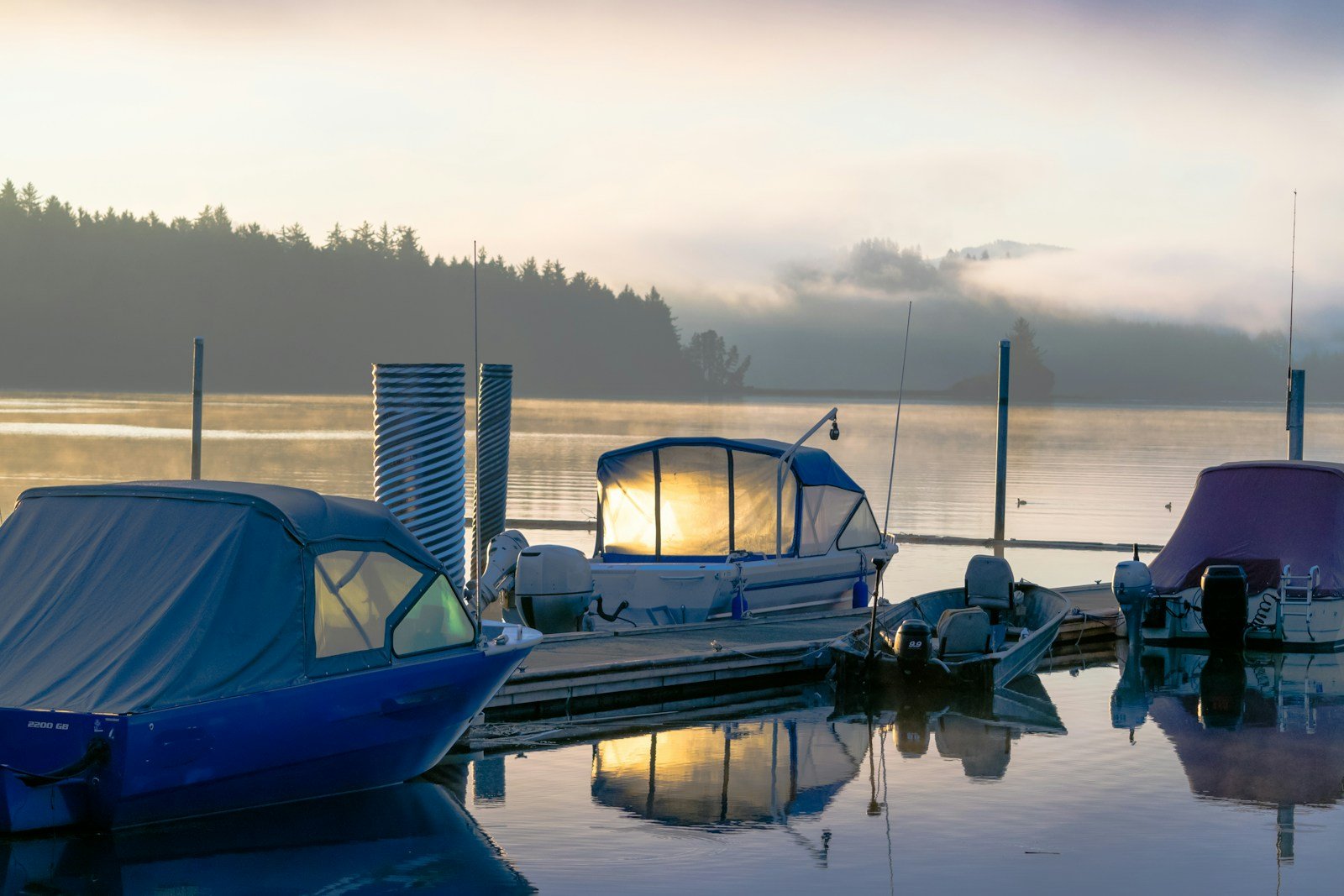 Un ponton de port au petit matin, embarcations amarrées